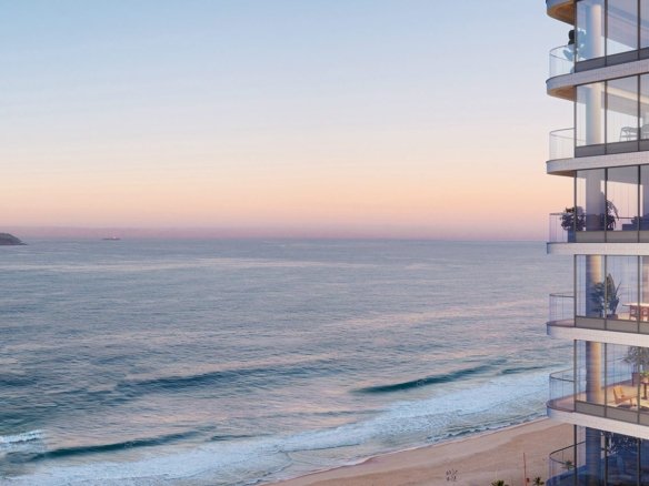Trecho da fachada ao amanhecer, com varandas em curva, e ao lado o mar, a faixa de areia e as Ilhas Cagarras no horizonte.