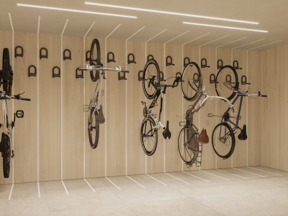 Sala revestida de madeira clara com bicicletas penduradas na vertical em suportes de parede e a palavra BIKE aplicada em relevo.
