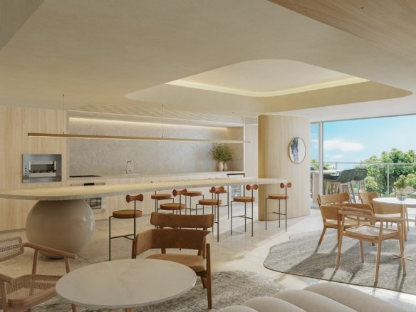 Salão com bancada longa de pedra sobre base esférica, banquetas, cooktop e forno embutidos na marcenaria, mesas de jantar e saída para o terraço.