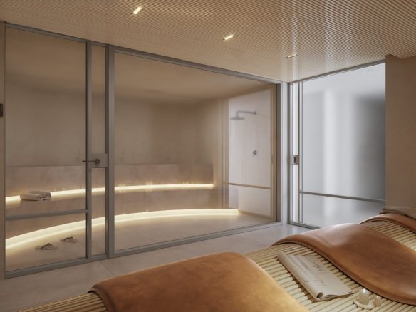 Cabine de sauna envidraçada com banco iluminado e chuveiro ao fundo, e em primeiro plano duas espreguiçadeiras de madeira com estofado em couro.